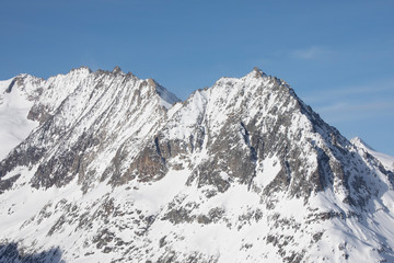 Fototapeta na wymiar verschneite Bergspitze in der Sonne Bergfels