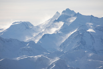 Fototapeta na wymiar Verschneite Berge mit Nebel in den Alpen