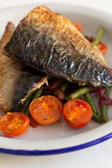 fried mackerel with vegetables close up.