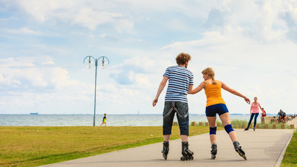 Young couple on roller skates riding outdoors