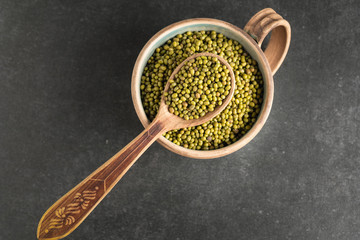 fresh mung beans in ceramic dishes against a dark stone background