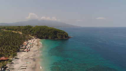 Naklejka premium sandy beach with palm trees in tropical resort. aerial seascape sand beach with turquoise water. Seascape, ocean and beautiful beach.Travel concept. Indonesia, Bali