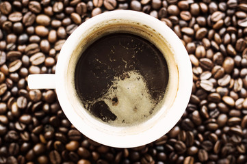 White cup of coffee on a coffee bean surface