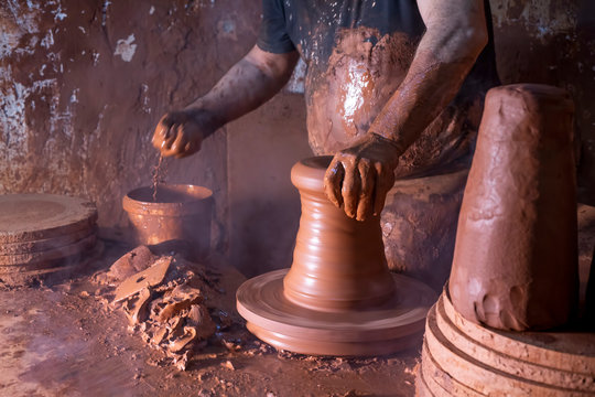 Professional potter making bowl in pottery workshop, studio.