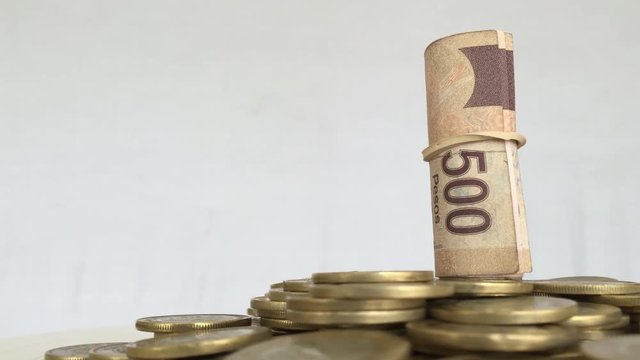 Mexican currency over mexican coins