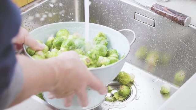 washing raw Brussels sprouts in kitchen sink