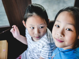 Happy Asian children enjoy their drink in coffee shop, lifestyle concept.