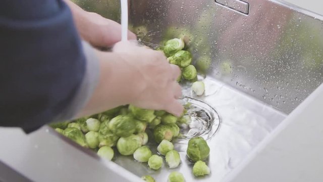 washing raw Brussels sprouts in kitchen sink