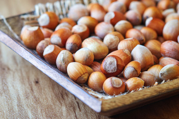 Fresh ripe organic hazelnuts (filbert) in a wooden bowl