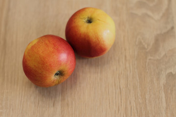 Naklejka na ściany i meble two red fresh apples on wooden table