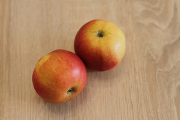 two red fresh apples on wooden table