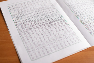 Obraz premium Learning and practice: workbook / notebook with a lot of chinese and japanese language characters (kanji) (translation - man, like, eye and others) 