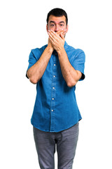 Handsome man with blue shirt covering mouth with hands