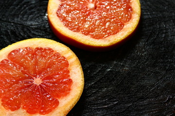 Grapefruitscheiben auf schwarzem Holzuntergrund