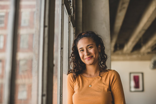 Portrait Of Smiling Woman Standing By Window