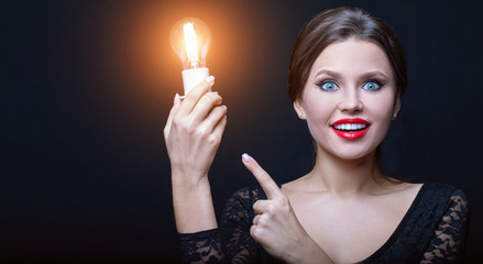 Obraz premium in the dark cold Studio girl holding a warm light, and happy about it. The concept of warmth and inspiration