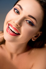 portrait of beautiful smiling woman with glamorous makeup looking at camera