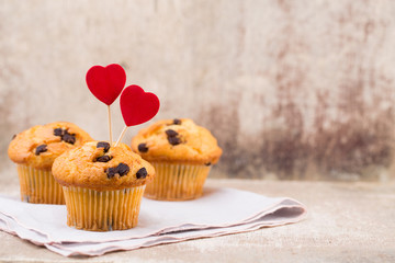 Homemade chocolate muffins with heart, vintage background.