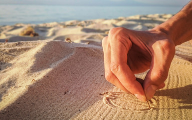 Hand drawing in the sand