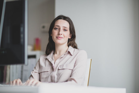 Portrait of a female business executive working in an office on a desktop computer