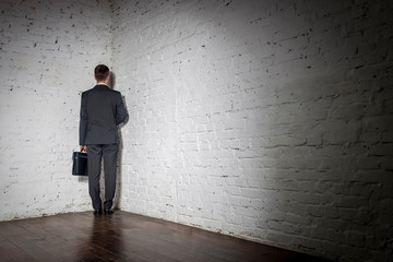 Full length rear view of businessman standing in corner at office