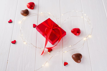 Valentine's Chocolate-Love sweet heart shaped chocolates candies with gift box on a white wooden background