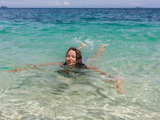 Happy girl swimming in the blue sea