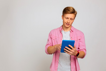 Handsome pleasant blonde man surfing the Internet