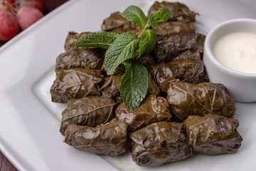 Azerbaijani dolma in grape leaves on a white plate