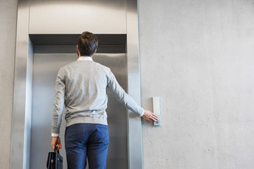 Rear view of businessman waiting for elevator at office © MDBPIXS