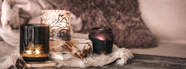 still life home atmosphere in the interior with candles and a book on the background of cozy bedspreads