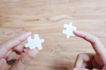 Closeup hand of woman connecting jigsaw puzzle with sunlight effect, Business solutions, success...
