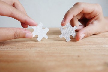 Closeup hand of woman connecting jigsaw puzzle with sunlight effect, Business solutions, success...