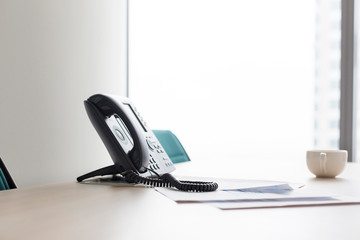 Closeup of landline phone on desk in modern office