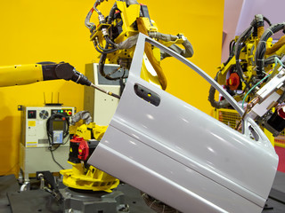 Robot arm demonstrate spot welding car door. Smart industrial manufacturing in automotive factory.