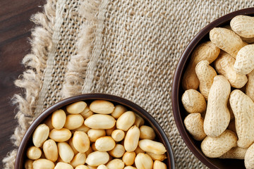 Peanuts in the shell and peeled closeup in a cup