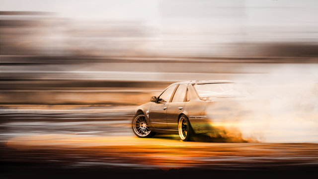 Double exposure sunset with car drifting, Blurred of image diffusion race drift car with lots of smoke from burning tires