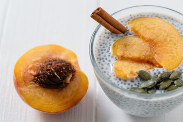 Cinnamon stick in a Cup with milk and Chia seeds on a white wooden table. The view from the top.