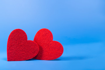Fototapeta premium Two red flat hearts on a blue background
