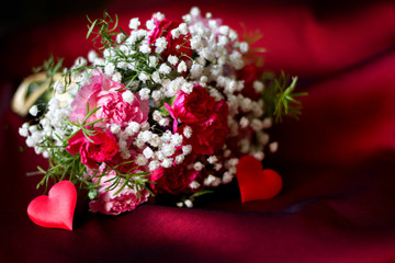 Bouquet of flowers on red fabric romantic love valentine's day floral background concept with heart shape

