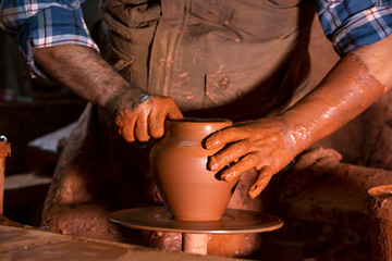 Professional potter making bowl in pottery workshop, studio.