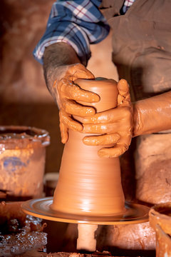 Professional potter making bowl in pottery workshop, studio.