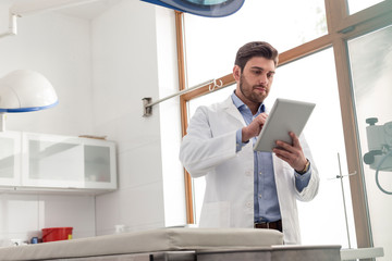 Veterinary doctor using digital tablet while standing at clinic