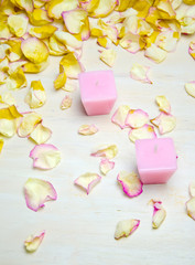 petals and candles on wooden background selective 