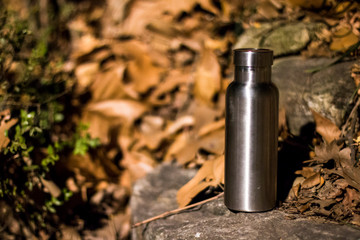 an insulated stainless steel bottle at the forest in the night