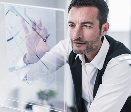 Businessman working in office, using futuristic computer with a transparent screen