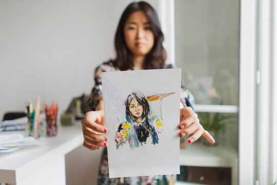 Illustrator showing drawing with self-portrait