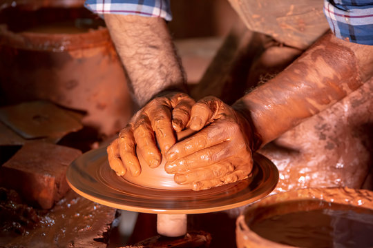 Professional potter making bowl in pottery workshop, studio.
