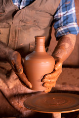 Professional potter making bowl in pottery workshop, studio.