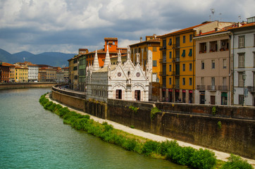 Fototapeta na wymiar View on Arno River in Pisa with gothic cathedral Santa Maria della Spina